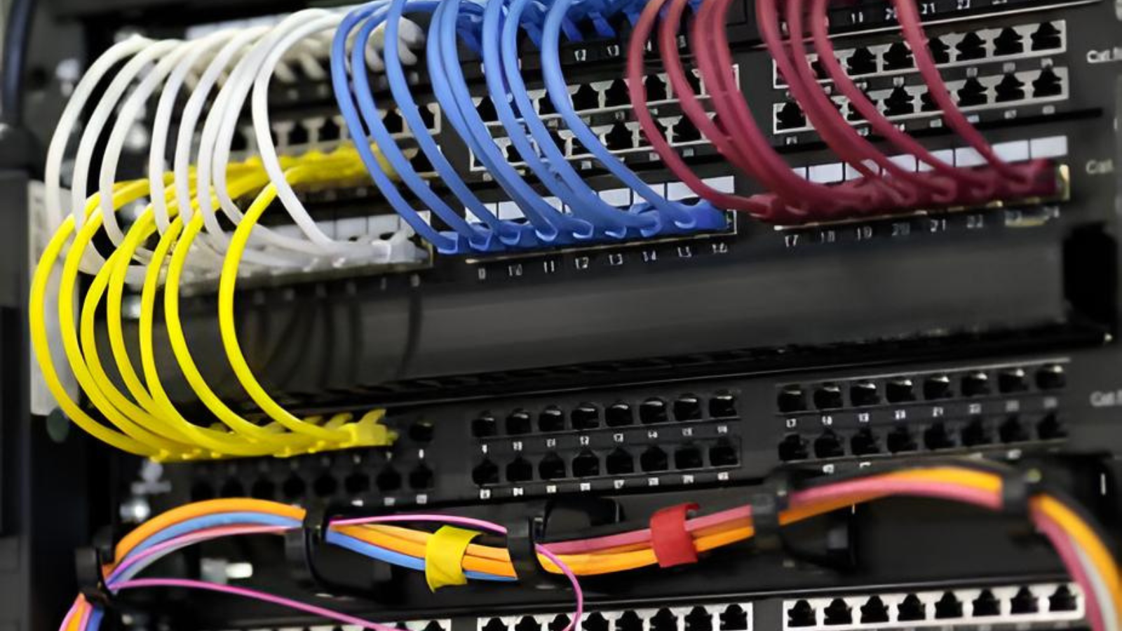 Close-up of a network server rack with multiple connected colored ethernet cables, organized and plugged into network switch ports&mdash;showcasing a setup aligned with the McDonald&rsquo;s NRBES 2027 compliance installation process.