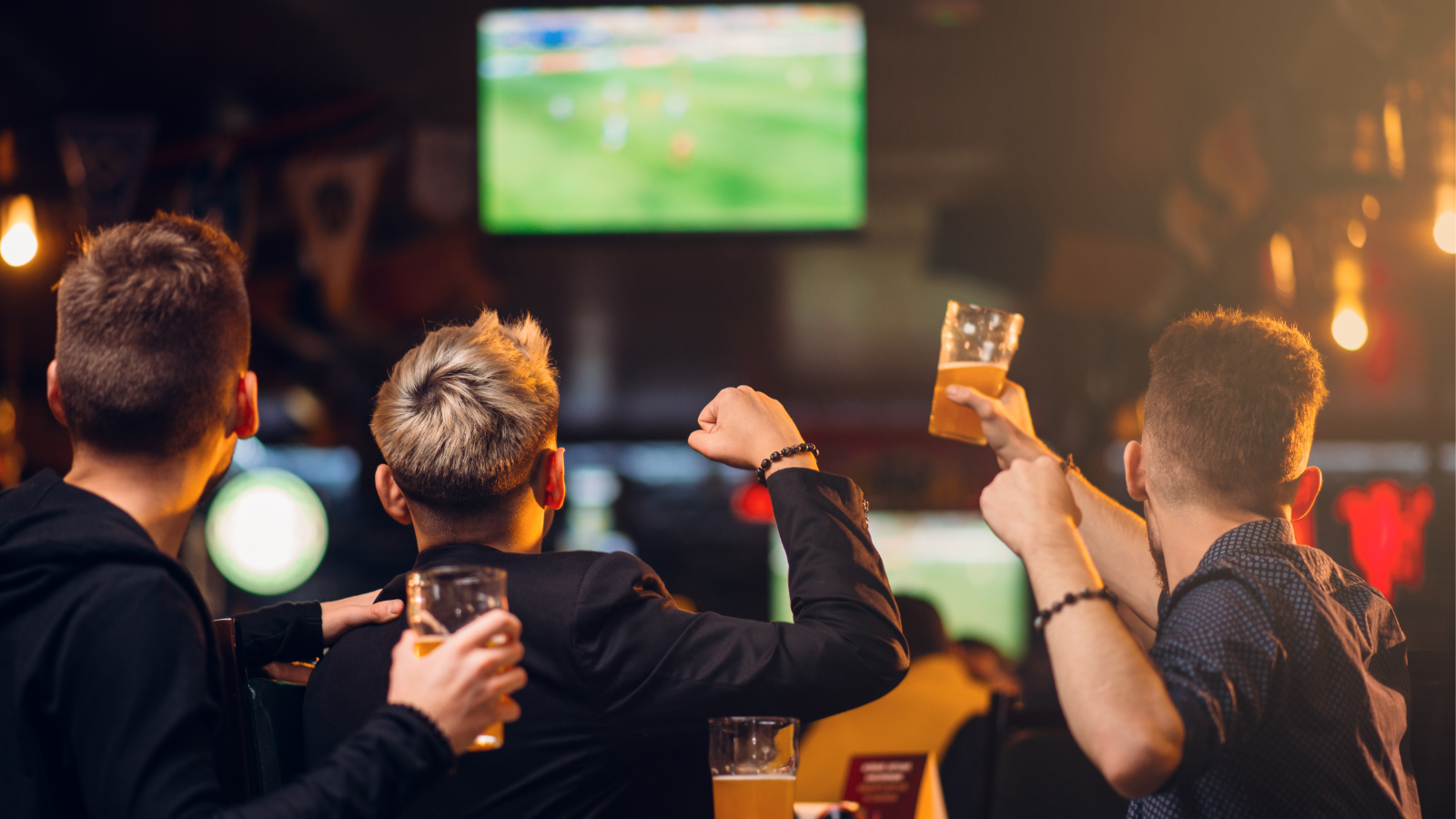 Busy sports bar with multiple televisions showing live games and customers watching sports